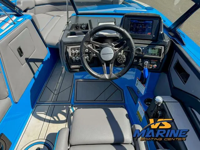 Slide: The Image of 2022 Moomba Makai boat cockpit with steering wheel, control panel, and blue-gray interior. - 20