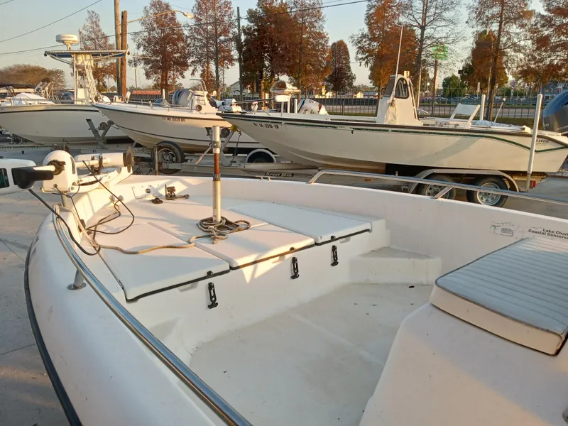 Slide: The Image of 2000 Champion 21 Bay Champ boat on trailer, parked outdoors with other boats. - 10