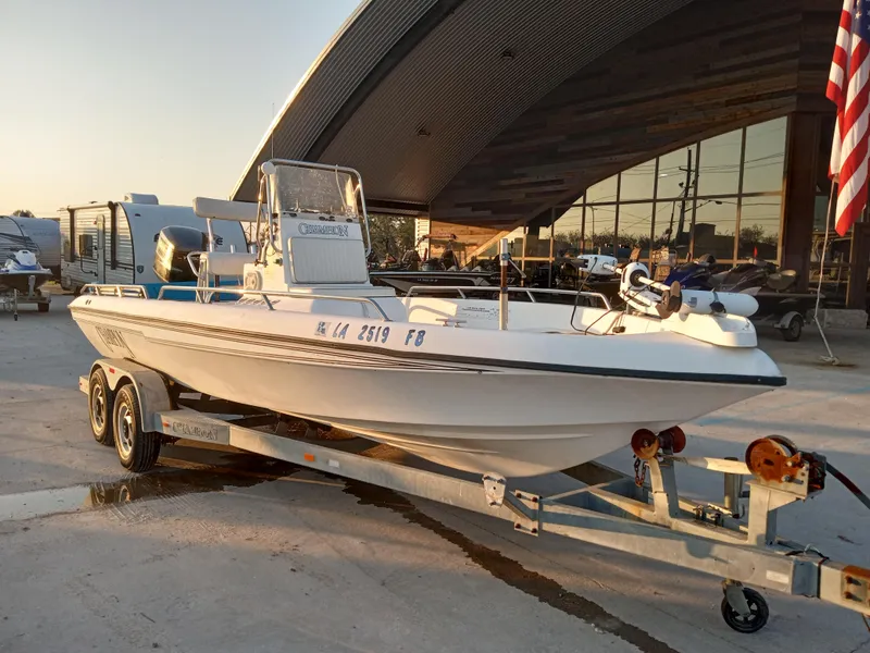 Slide: The Image of 2000 Champion 21 Bay Champ boat on trailer, parked outdoors near a building. - 4