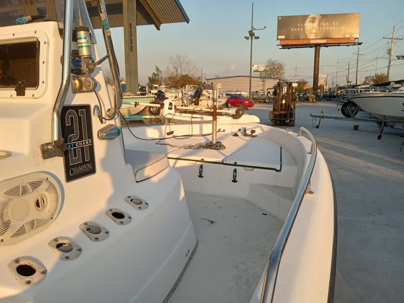 Slide: The Image of 2000 Champion 21 Bay Champ boat at marina, sunny day, billboard in background. - 7