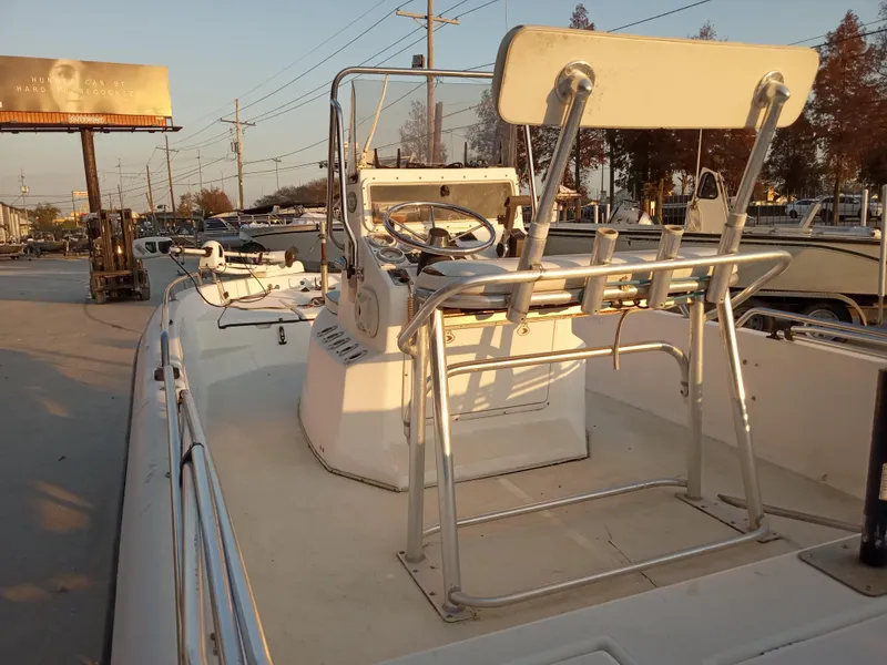 Slide: The Image of 2000 Champion 21 Bay Champ boat with steering console and seating, parked outdoors. - 9