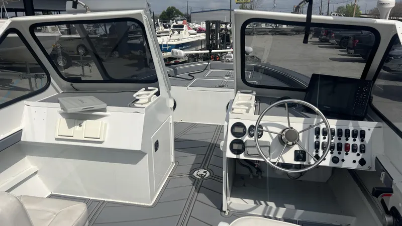 Slide: The Image of Interior of a 2000 Gravois 22' Dual Console Hybrid boat, featuring steering controls and dashboard. - 10
