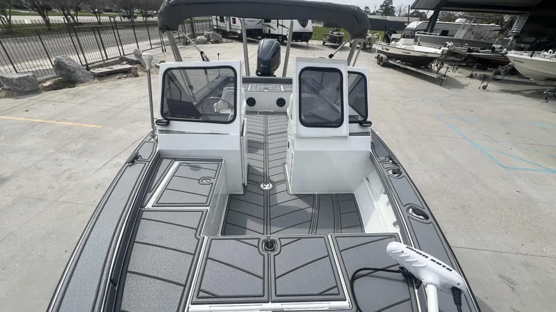 Slide: The Image of 2000 Gravois 22' Dual Console Hybrid boat with modern deck design in a marina setting. - 12
