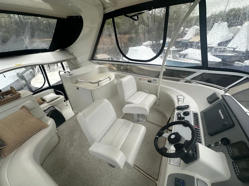 Slide: The Image of 2007 Carver 43 Motor Yacht interior with helm, white seating, and panoramic windows. - 10