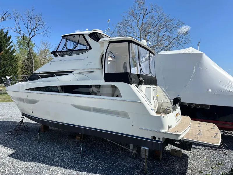 Slide: The Image of 2007 Carver 43 Motor Yacht on stands, surrounded by trees and clear blue sky. - 2