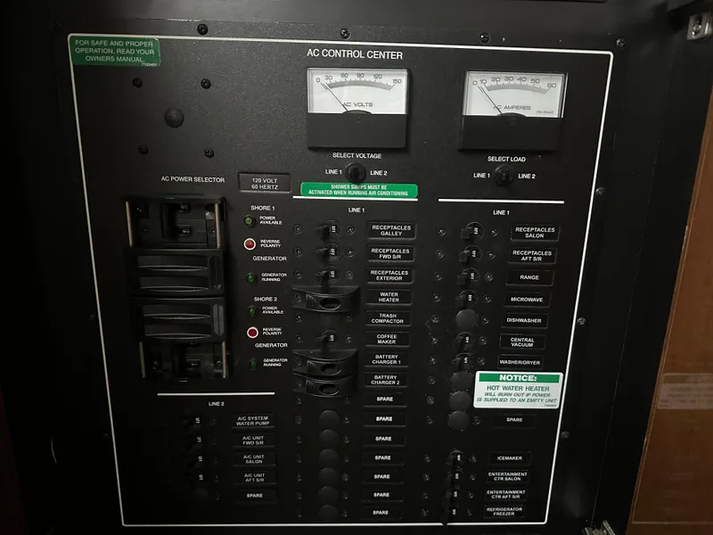 Slide: The Image of AC control panel on a 2007 Carver 43 Motor Yacht, showing voltage and amperage meters. - 38