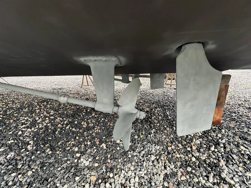 Slide: The Image of Underneath view of a 2007 Carver 43 Motor Yacht showing propeller and rudder on gravel. - 51