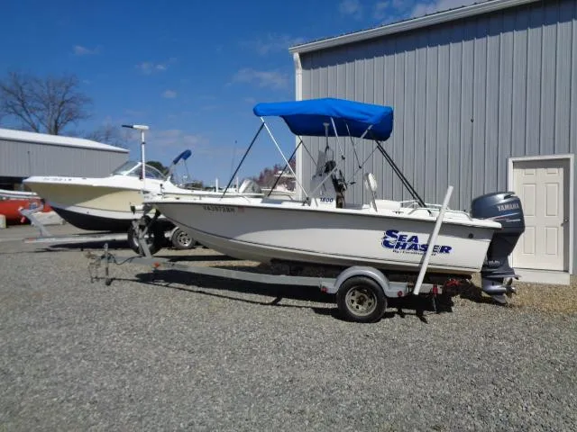 Slide: The Image of 2005 Sea Chaser 1800 RG boat with blue canopy on trailer, parked outdoors. - 1