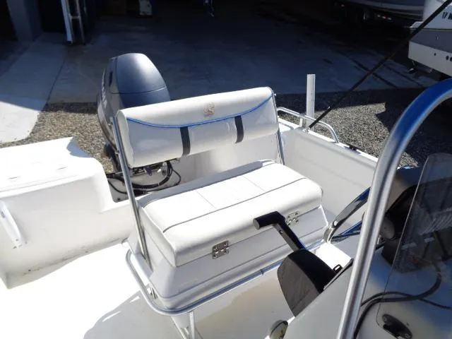Slide: The Image of 2005 Sea Chaser 1800 RG boat interior with white seating and motor. - 11