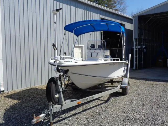 Slide: The Image of 2005 Sea Chaser 1800 RG boat with blue canopy on trailer, parked outside a metal building. - 2