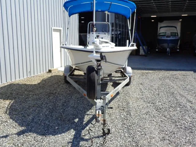 Slide: The Image of 2005 Sea Chaser 1800 RG boat on trailer with blue canopy, parked outside a garage. - 3