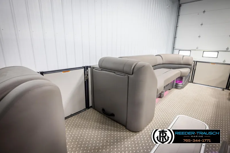 Slide: The Image of 2022 Avalon Catalina VRB pontoon boat interior with plush seating in a spacious garage. - 19