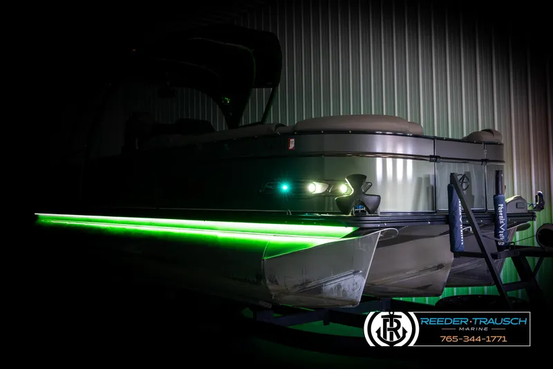 Slide: The Image of 2022 Avalon Catalina VRB pontoon boat with green LED lights in a dimly lit setting. - 3
