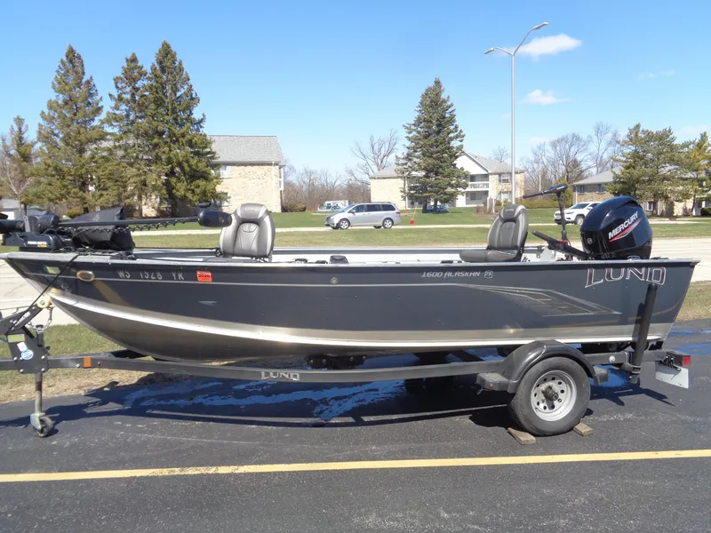 The Image of 2023 Lund 1600 Alaskan Tiller boat on trailer, parked outdoors. - 0