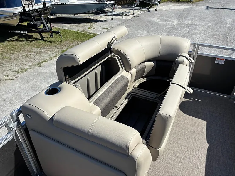 Slide: The Image of 2025 Sun Tracker Party Barge 20 DLX with beige seating and storage compartments. - 12