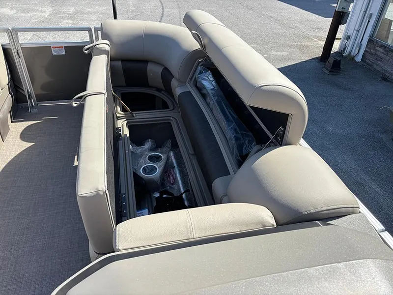 Slide: The Image of 2025 Sun Tracker Party Barge 20 DLX interior with open storage and cup holders. - 14