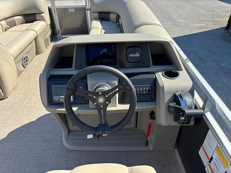 Slide: The Image of 2025 Sun Tracker Party Barge 20 DLX dashboard with steering wheel and controls. - 19