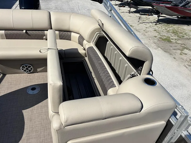 Slide: The Image of 2025 Sun Tracker Party Barge 20 DLX interior with beige seating and storage compartments. - 21