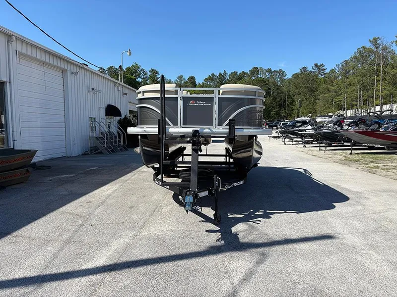 Slide: The Image of 2025 Sun Tracker Party Barge 20 DLX pontoon boat parked outdoors on a sunny day. - 3