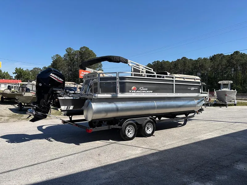 Slide: The Image of 2025 Sun Tracker Party Barge 20 DLX pontoon boat on trailer, outdoors. - 6