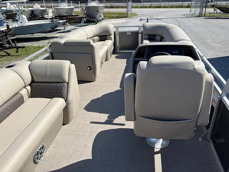 Slide: The Image of 2025 Sun Tracker Party Barge 20 DLX interior with beige seating and steering console. - 9