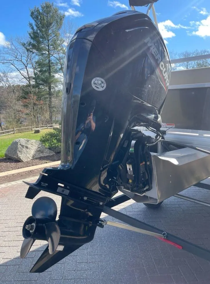 Slide: The Image of 2025 Sun Tracker Party Barge 18 DLX outboard motor, parked outdoors on a sunny day. - 8