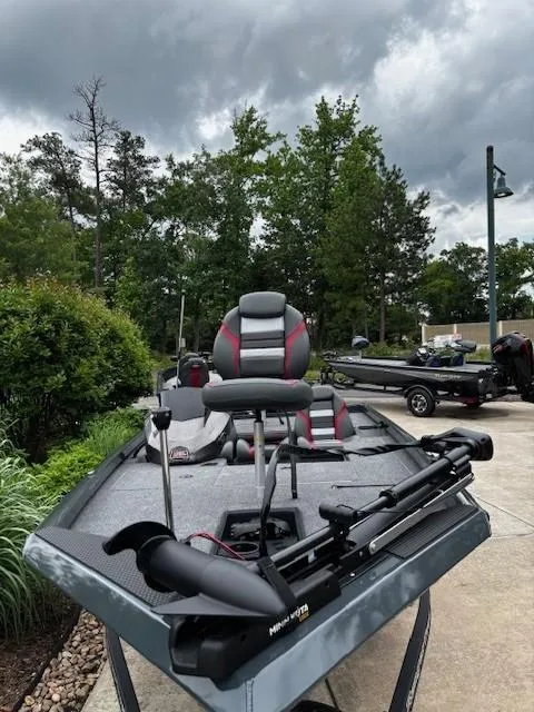 Slide: The Image of 2025 Ranger RT178 boat with trolling motor, parked outdoors under cloudy sky. - 2
