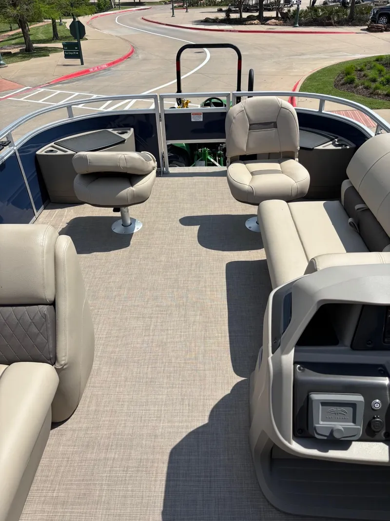 Slide: The Image of 2025 Sun Tracker Fishin' Barge 20 DLX interior with beige seating and spacious deck. - 3