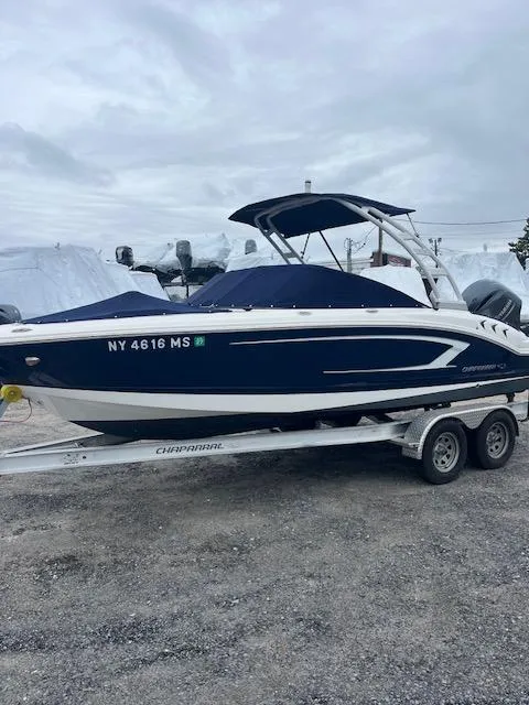 Slide: The Image of 2021 Chaparral 21 SSi OB boat on trailer, blue and white design, overcast sky. - 1