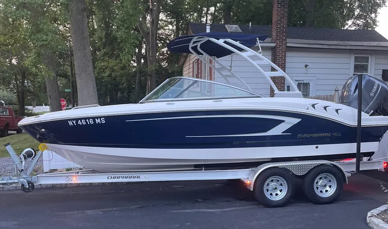 Slide: The Image of 2021 Chaparral 21 SSi OB boat on trailer, parked near a house. - 12