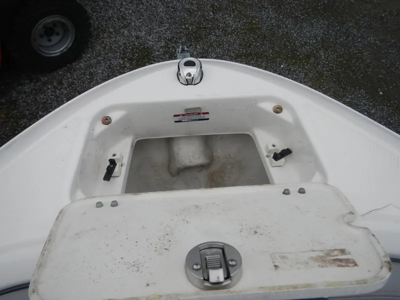 Slide: The Image of 2021 Chaparral 21 SSi OB boat anchor compartment, open and empty, with visible latch. - 14