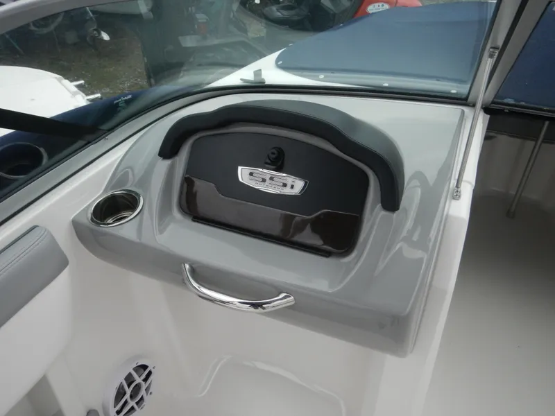 Slide: The Image of 2021 Chaparral 21 SSi OB boat dashboard with storage compartment and cup holder. - 28
