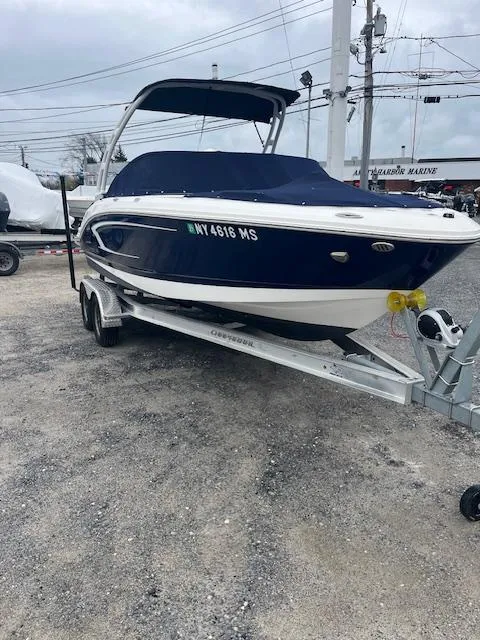 Slide: The Image of 2021 Chaparral 21 SSi OB boat on trailer, blue and white design, parked outdoors. - 4
