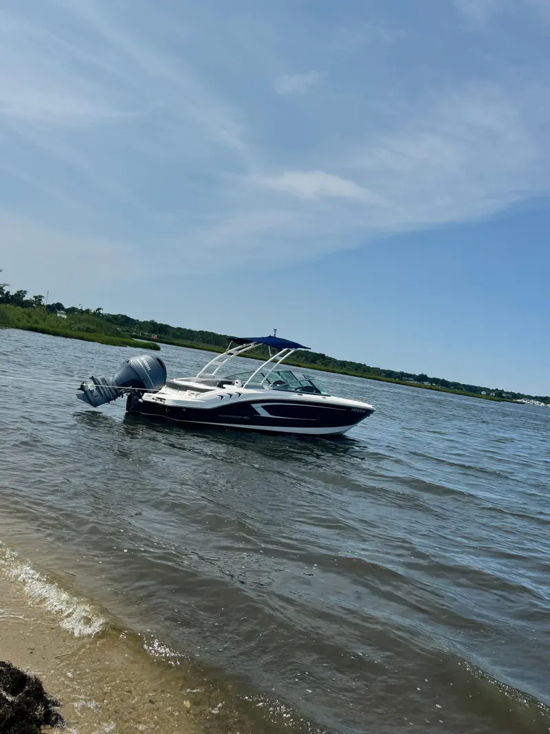 Slide: The Image of 2021 Chaparral 21 SSi OB boat on calm water under clear blue sky. - 8