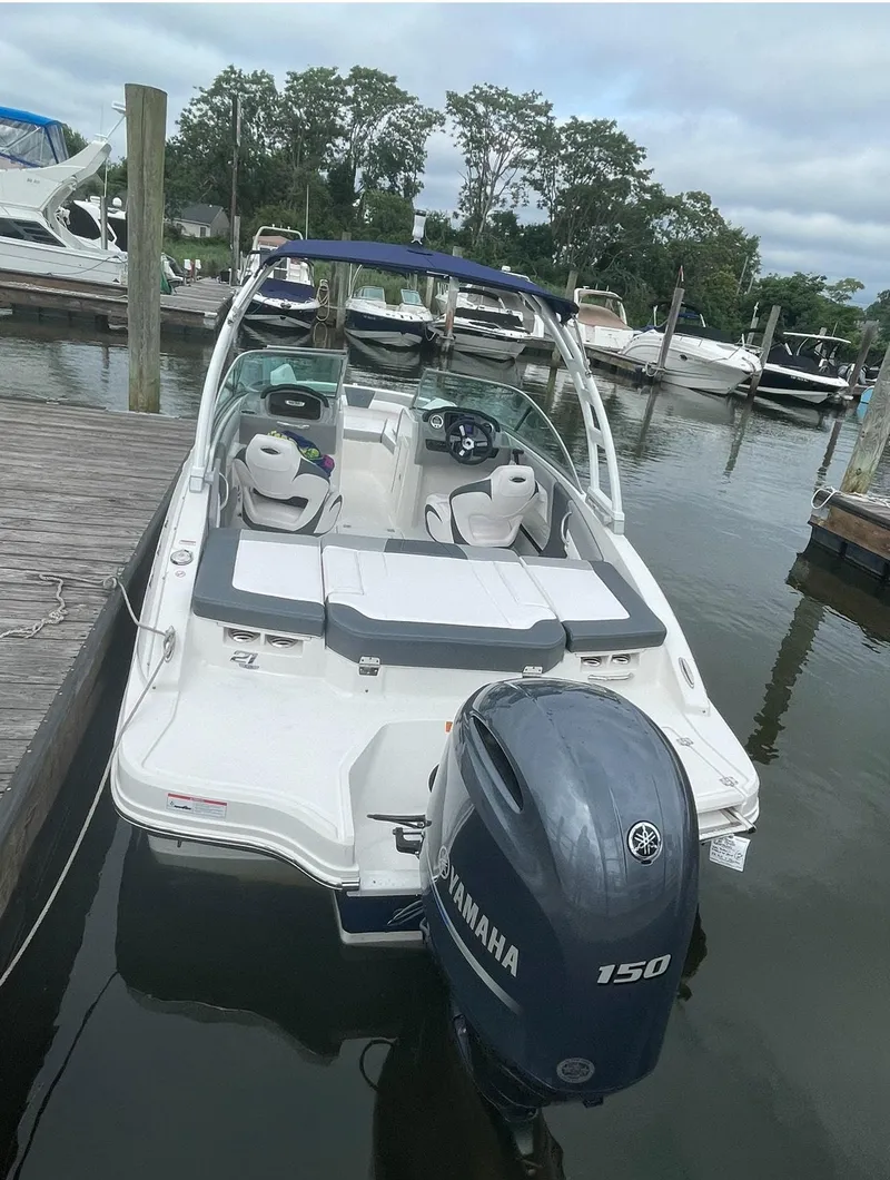 Slide: The Image of 2021 Chaparral 21 SSi OB boat docked, featuring Yamaha 150 outboard motor. - 9