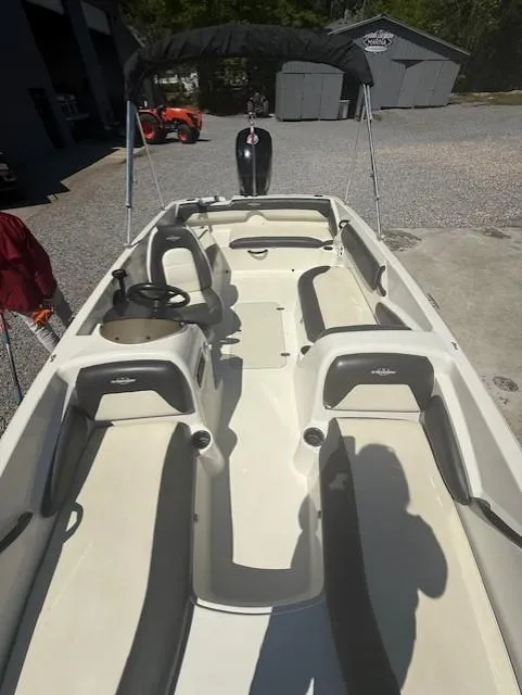 Slide: The Image of 2018 Stingray 182 SC boat with seating and canopy in a gravel lot. - 5