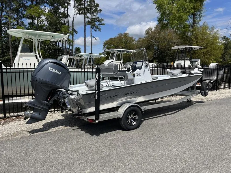 Slide: The Image of 2025 Xpress H20B boat with Yamaha outboard motor on a trailer, parked outdoors. - 2