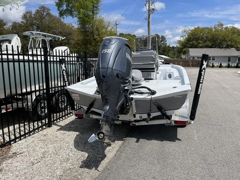 Slide: The Image of 2025 Xpress H20B boat with Yamaha 150 engine, parked near a fence. - 3