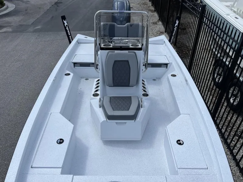 Slide: The Image of 2025 Xpress H20B boat with center console and seating, docked near a fence. - 7