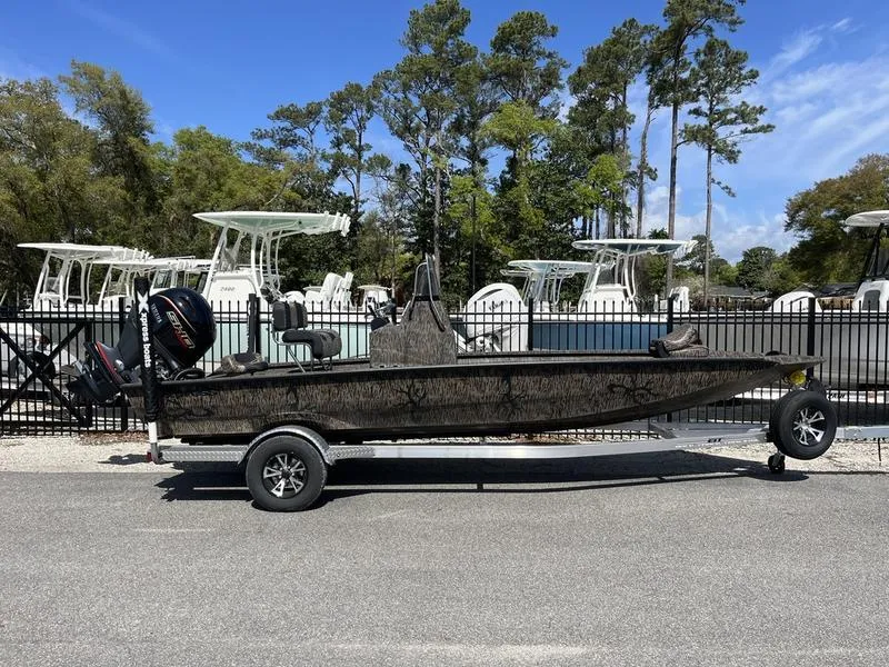 Slide: The Image of 2025 Xpress H210B boat on trailer, parked outdoors with trees in background. - 1