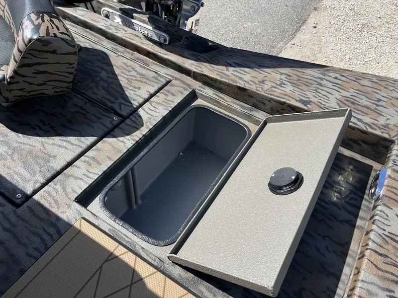 Slide: The Image of 2025 Xpress H210B boat with open storage compartment, camo pattern interior. - 12