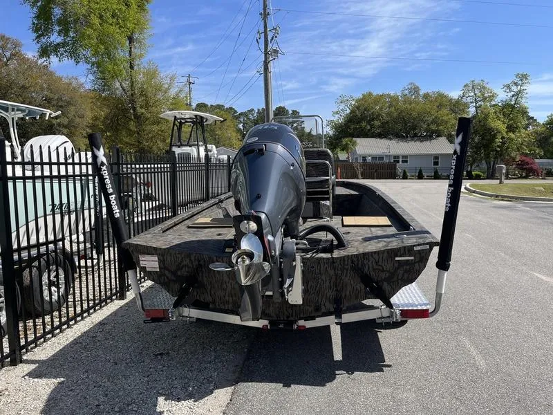 Slide: The Image of 2025 Xpress H210B boat on trailer, parked outdoors near a fence. - 3