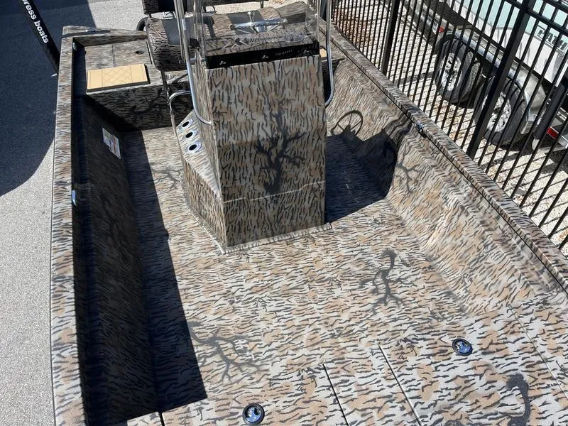 Slide: The Image of 2025 Xpress H210B boat with camouflage interior design, parked outdoors. - 7