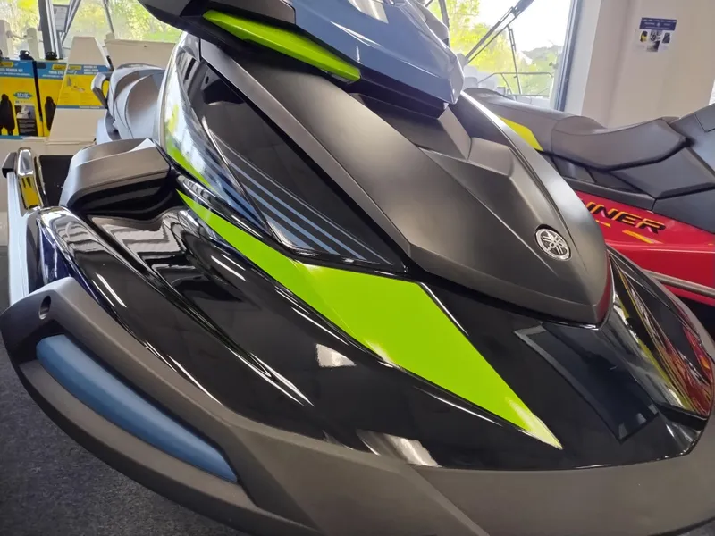Slide: The Image of 2024 Yamaha WaveRunner VX Deluxe in showroom, featuring sleek black and green design. - 2
