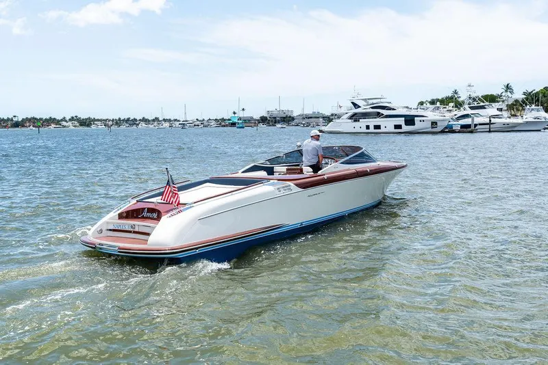 Slide: The Image of 2015 Riva Aquariva Super boat cruising on a sunny day near a marina. - 2