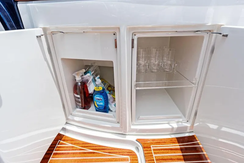 Slide: The Image of Storage compartments on a 2015 Riva Aquariva Super yacht, featuring cleaning supplies and glassware. - 39