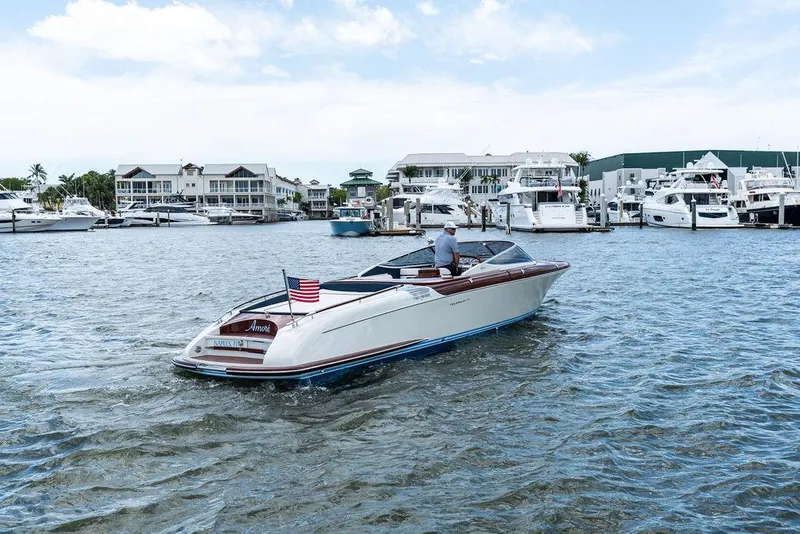 The Image of 2015 Riva Aquariva Super boat cruising in a marina with waterfront homes. - 0