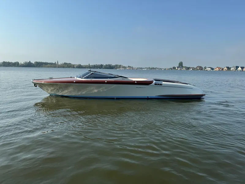 Slide: The Image of 2015 Riva Aquariva Super boat on calm water under clear blue sky. - 14