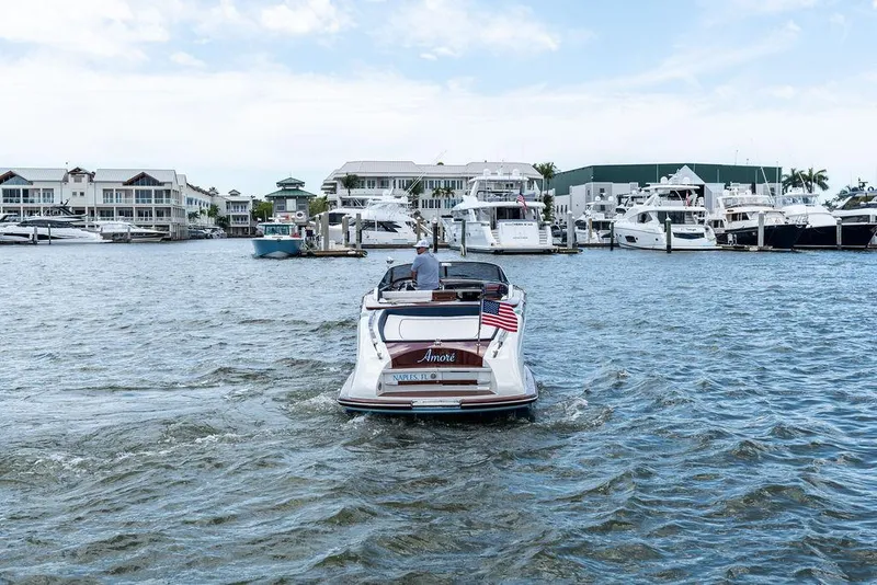 Slide: The Image of 2015 Riva Aquariva Super boat cruising in a marina with yachts and waterfront buildings. - 3