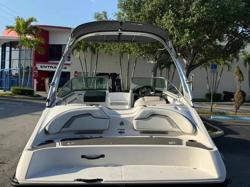 Slide: The Image of 2017 Yamaha Boats AR190, white interior, parked outdoors near trees and building. - 16